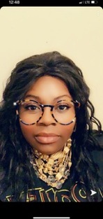 Shemeka Campbell smiling in gold statement jewelry and round glasses